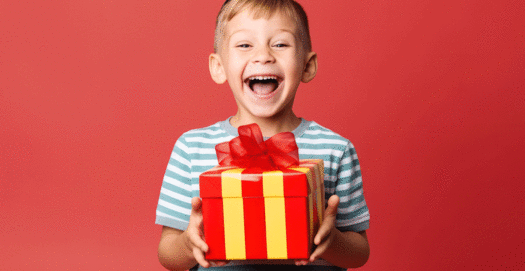 Freudestrahlender Junge mit Geschenk in der Hand - Foto von Olga Demina auf AdobeStock.com